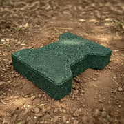 A closeup image of a green rubber paver on an outdoor dirt surface
