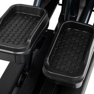 Close-up of the Spirit Fitness CE1000ENT Elliptical foot platforms shows the textured hexagonal, non-slip grip surface on both pedals.