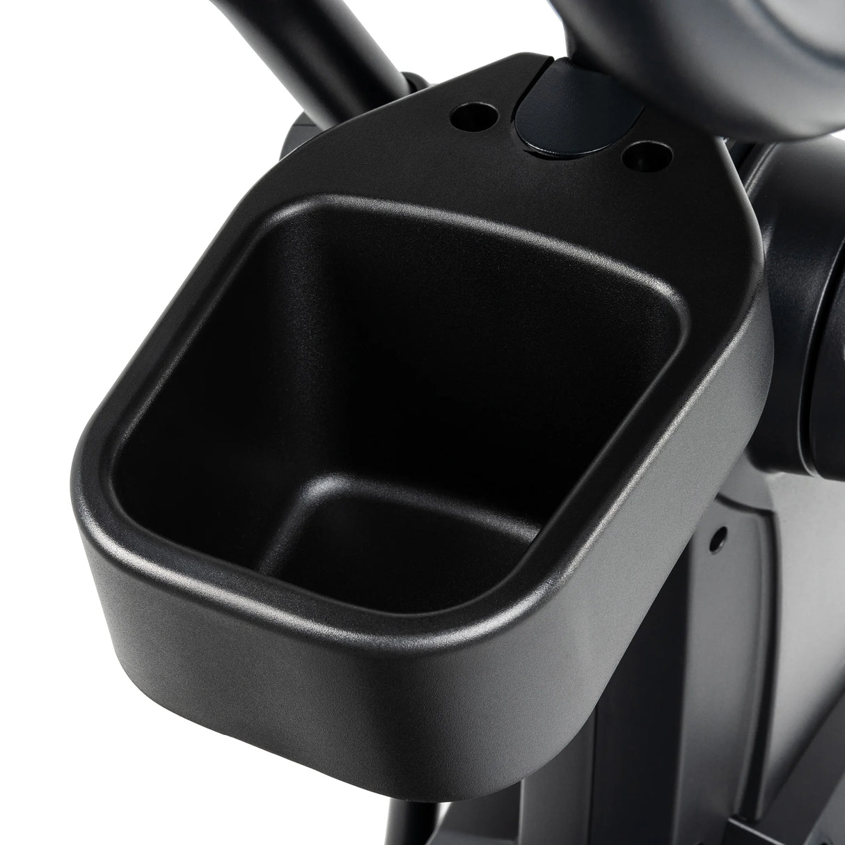 Close-up of a black plastic accessory tray or cup holder attached to the Spirit Fitness CE800ENT Elliptical by Spirit Fitness, ideal for holding a water bottle or small personal items during your workout.