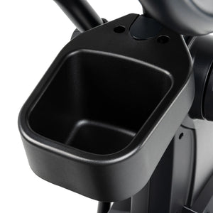 Close-up of a black plastic accessory tray or cup holder attached to the Spirit Fitness CE800ENT Elliptical by Spirit Fitness, ideal for holding a water bottle or small personal items during your workout.