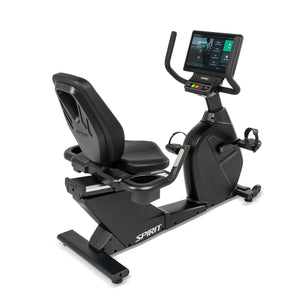 Three-quarter front view of the Spirit Fitness CR1000ENT Recumbent Bike highlighting the wide cushioned seat, adjustable backrest with carry handle, pedals with foot straps, and console mounted on a tall mast.