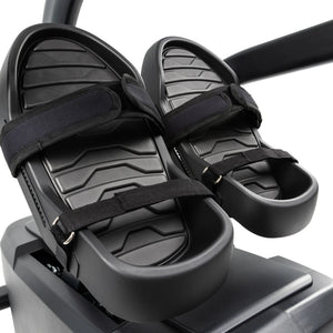Close-up of two black textured foot pedals with adjustable straps on the Spirit Fitness CRS800S Recumbent Seated Stepper by Spirit Fitness, set against a plain background.