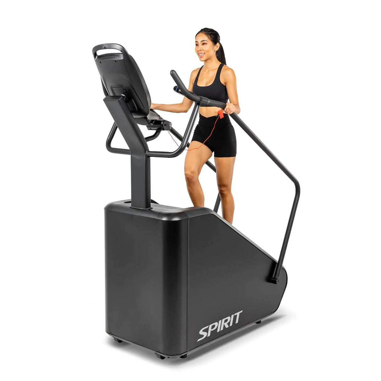 A woman using the Spirit Fitness CSC880 Stair Climber from a front-angle view, hand on the center console handrail.