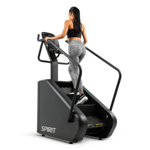 Rear-angle view of a woman climbing the Spirit Fitness CSC880 Stair Climber wearing grey leggings.