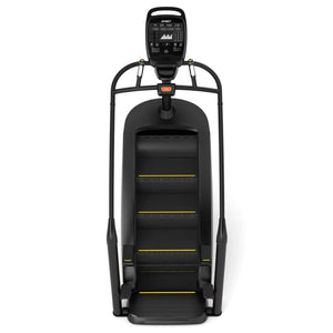 The Spirit Fitness CSC900 Stair Climber by Spirit Fitness is a black machine with yellow accents, dual handrails, and a digital display, shown from the front.