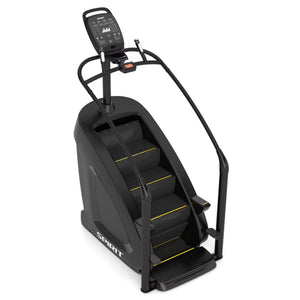 The Spirit Fitness CSC900 Stair Climber is a black exercise machine with handrails, a digital display, and yellow-accented steps from Spirit Fitness.