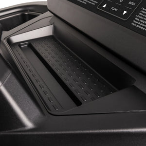 Close-up of a textured black tray with raised edges on the Spirit Fitness CT900 Treadmill, positioned below a control panel featuring buttons and a display screen from Spirit Fitness.