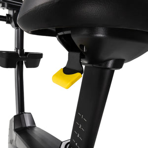 Close-up of the Spirit Fitness CU1000ENT Upright Bike seat area showing the seat rail, adjustable frame, and yellow quick-release seat-height lever with numbered position markings.
