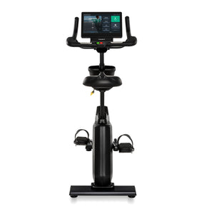 Front view of the black Spirit Fitness CU1000ENT Upright Bike showing the touchscreen console displaying a workout menu, handlebar grips, seat, and pedals aligned along the frame.