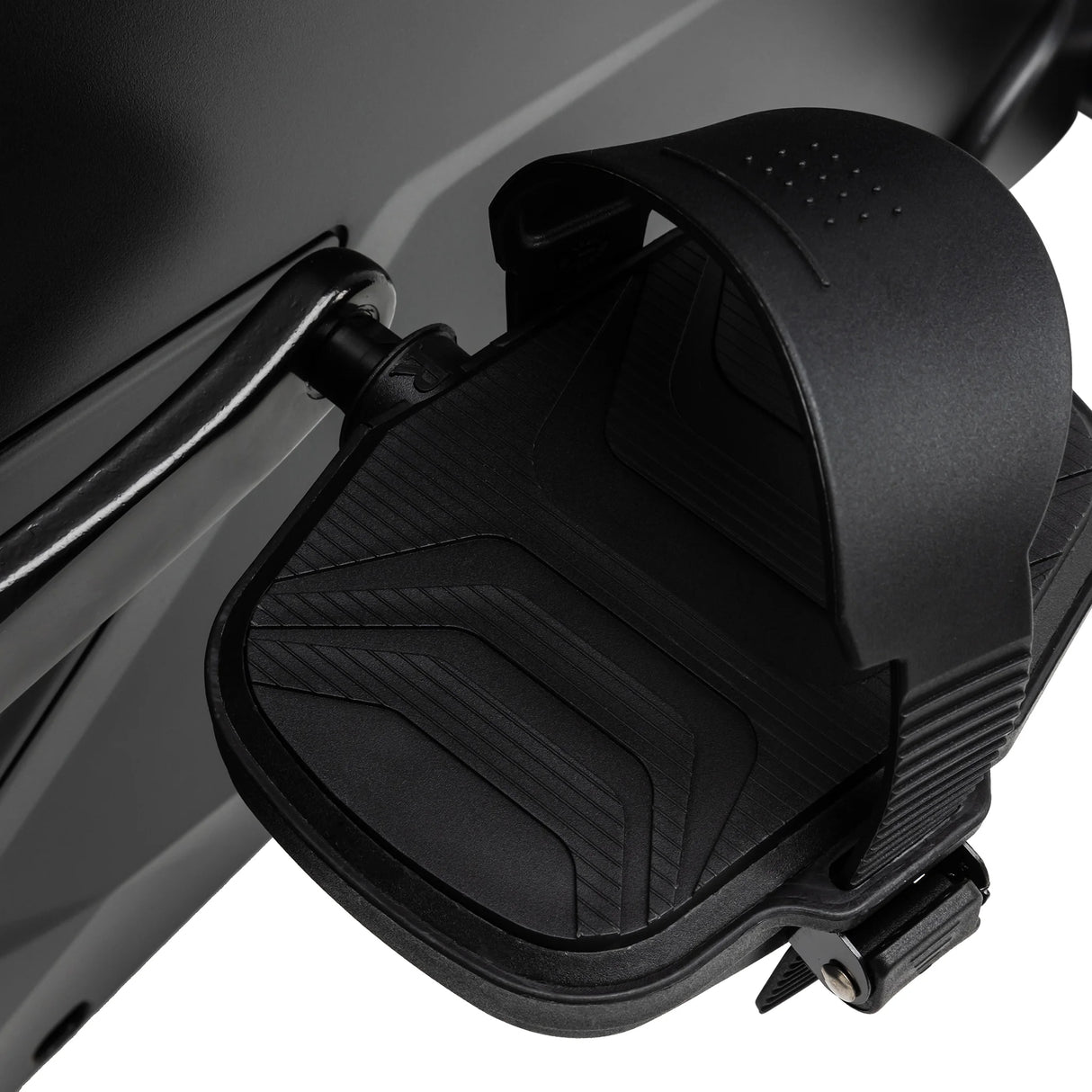 Close-up of the Spirit Fitness CU900 Upright Bike’s black pedal, featuring a textured surface and adjustable foot strap, set against the bike’s dark frame.